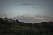 A peaceful Slovak countryside scene with rolling hills and a warm cream sky at dusk.