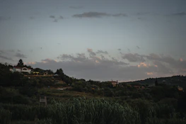 A peaceful Slovak countryside scene with rolling hills and a warm cream sky at dusk.