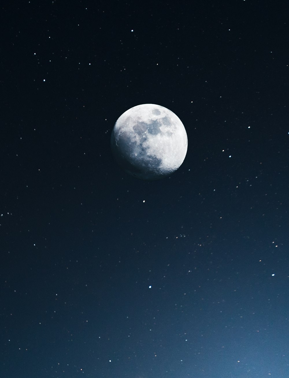 a full moon in the night sky with stars