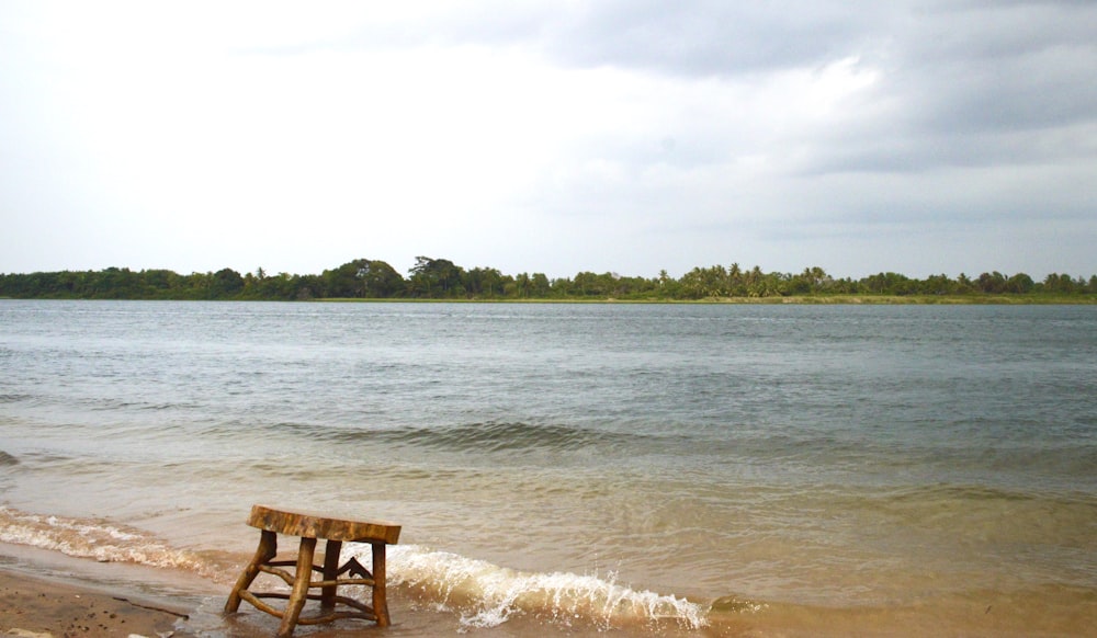 brown wooden chair on seashore during daytime