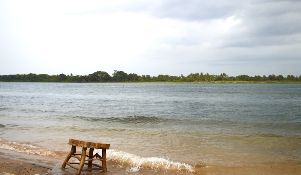 昼間の海岸の茶色の木製の椅子