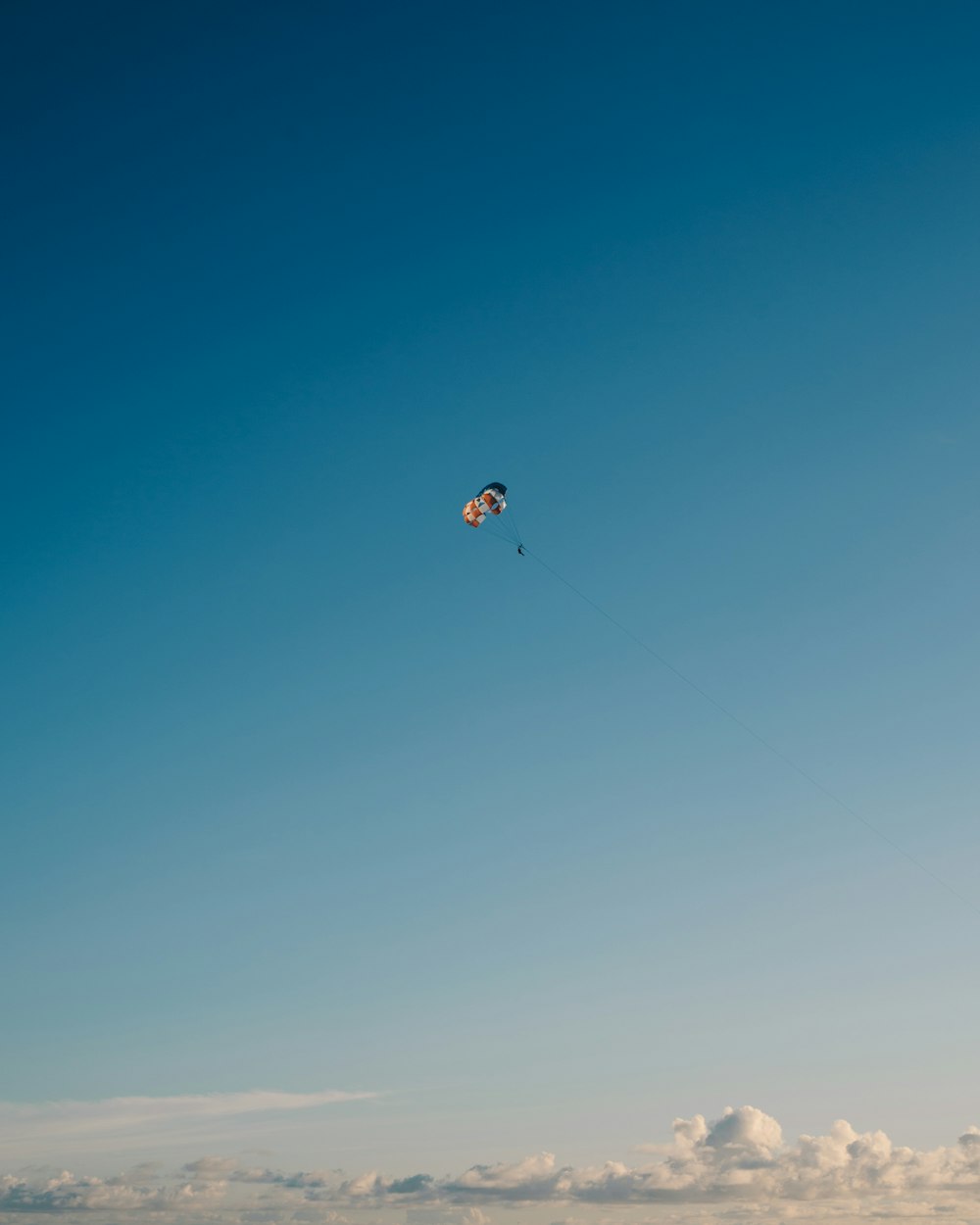 person in parachute under blue sky during daytime