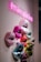 A neon pink sign with the hashtag #makeupkitchen hangs above a series of multicolored, geometric 3D sculptures of lips mounted on a wall. The lips are crafted in various shades, including pink, red, blue, and green, displaying an array of vibrant and metallic textures.