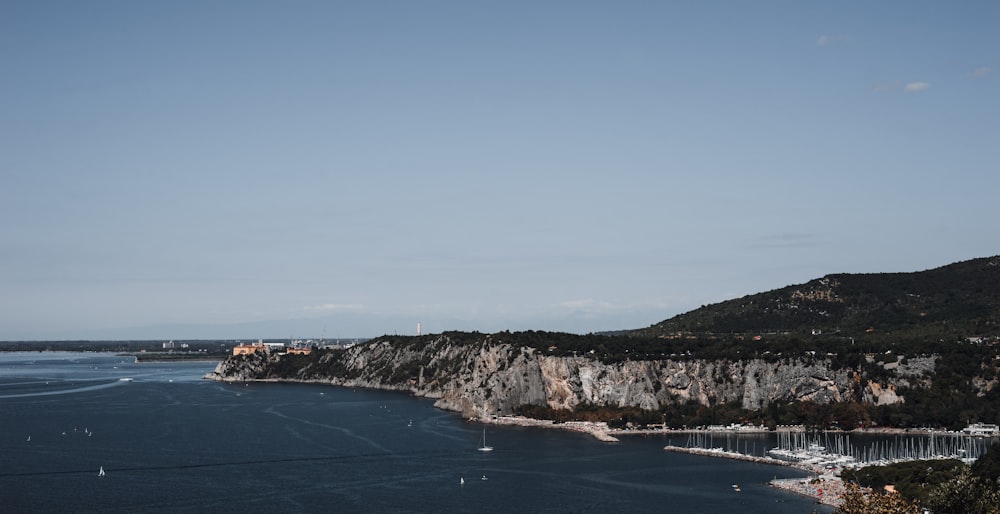 body of water near mountain during daytime