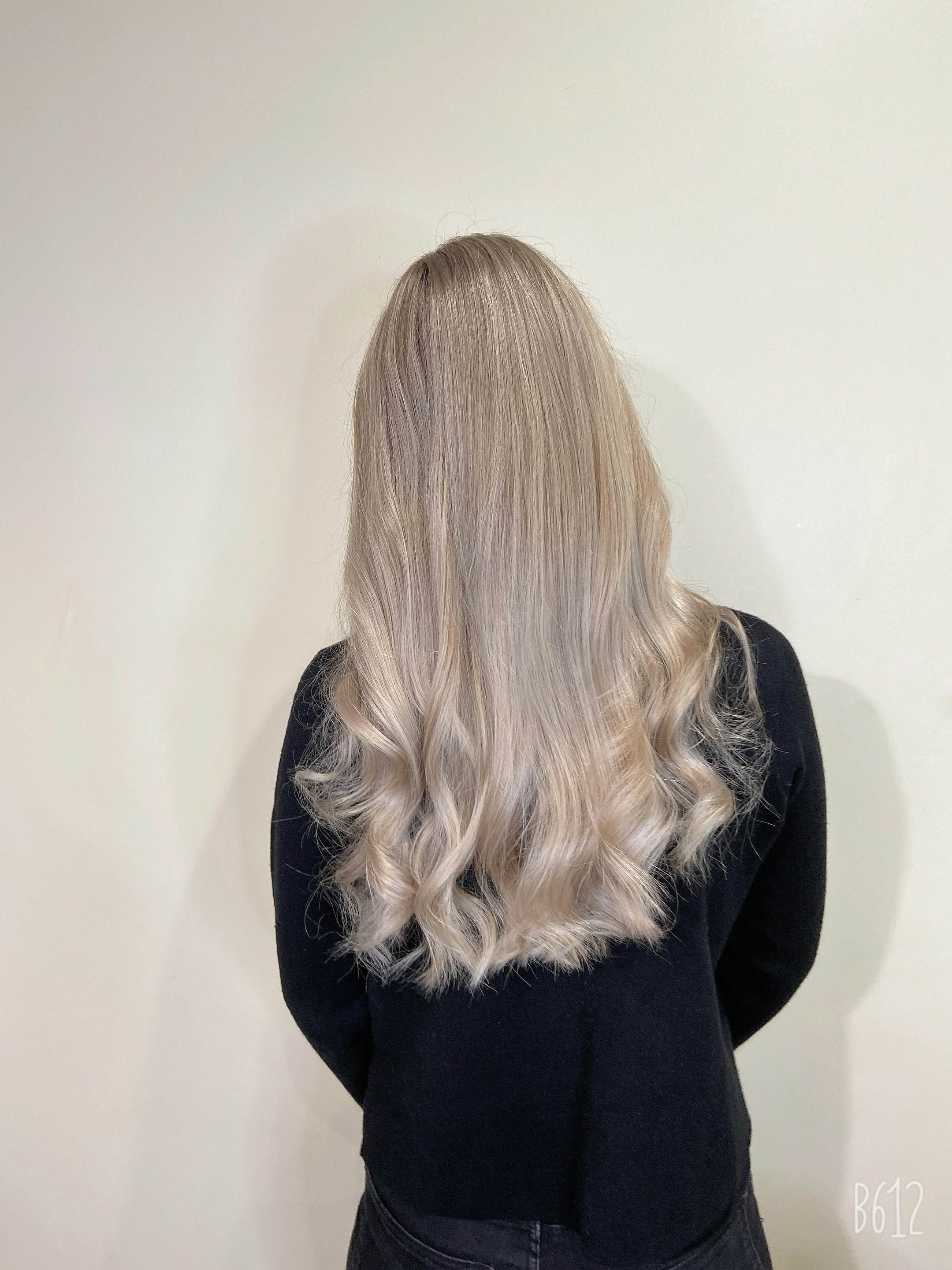 a woman with a ash blonde hair in black long sleeve shirt