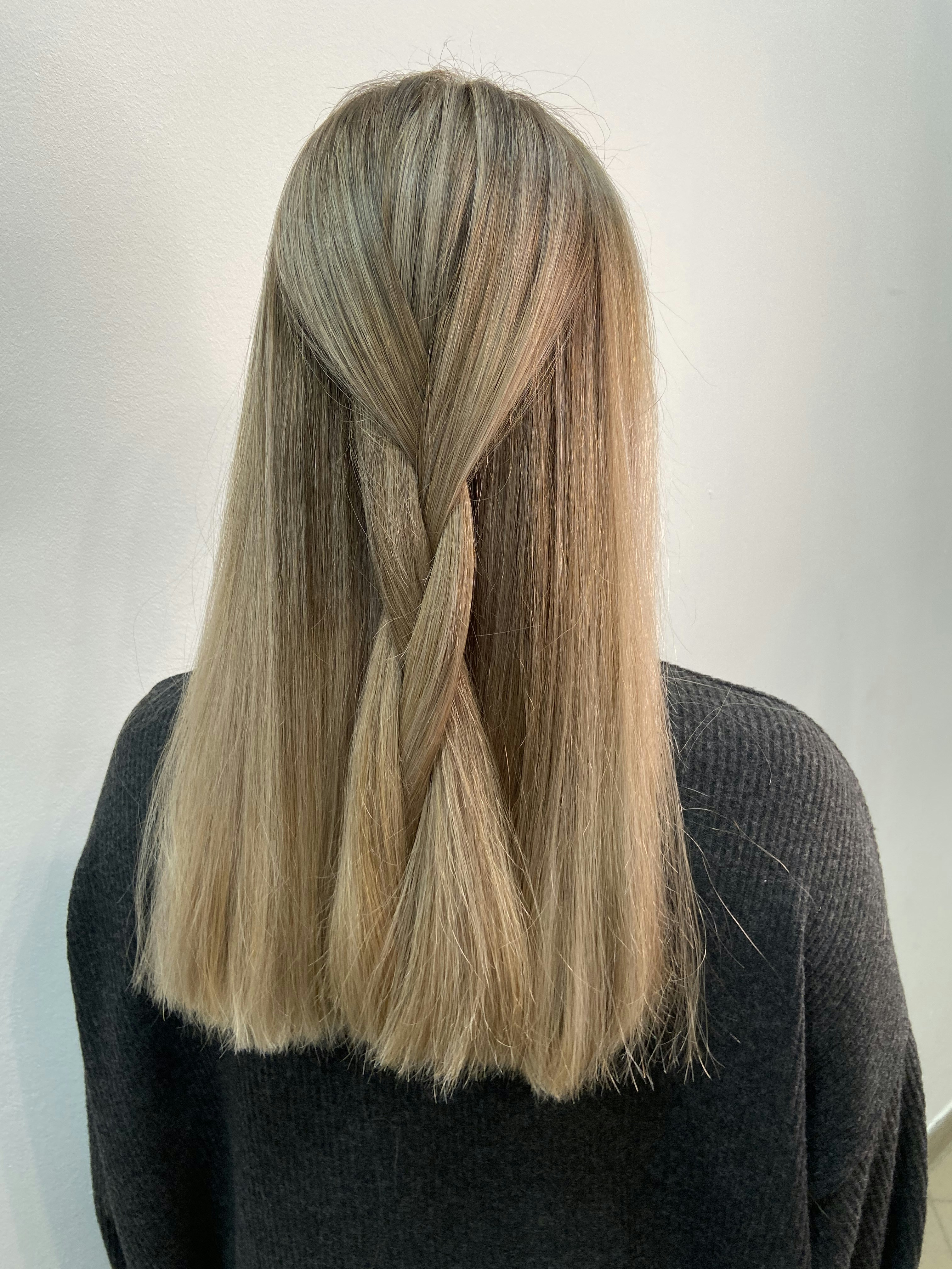 Back view of a simple half-up braided hairstyle on straight blonde hair