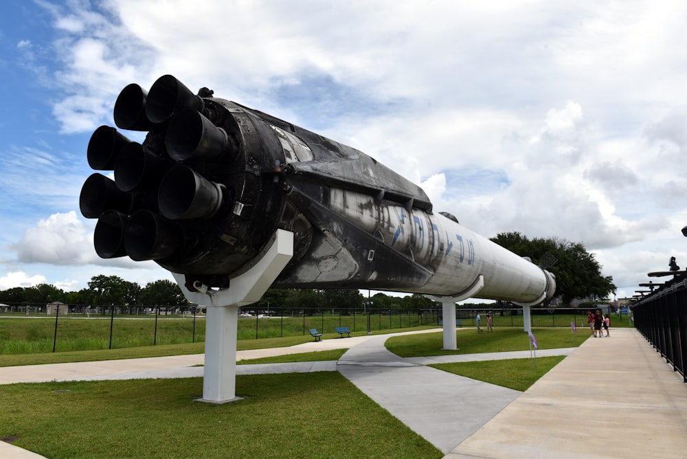 black and white space ship on green grass field under white cloudy sky during daytime