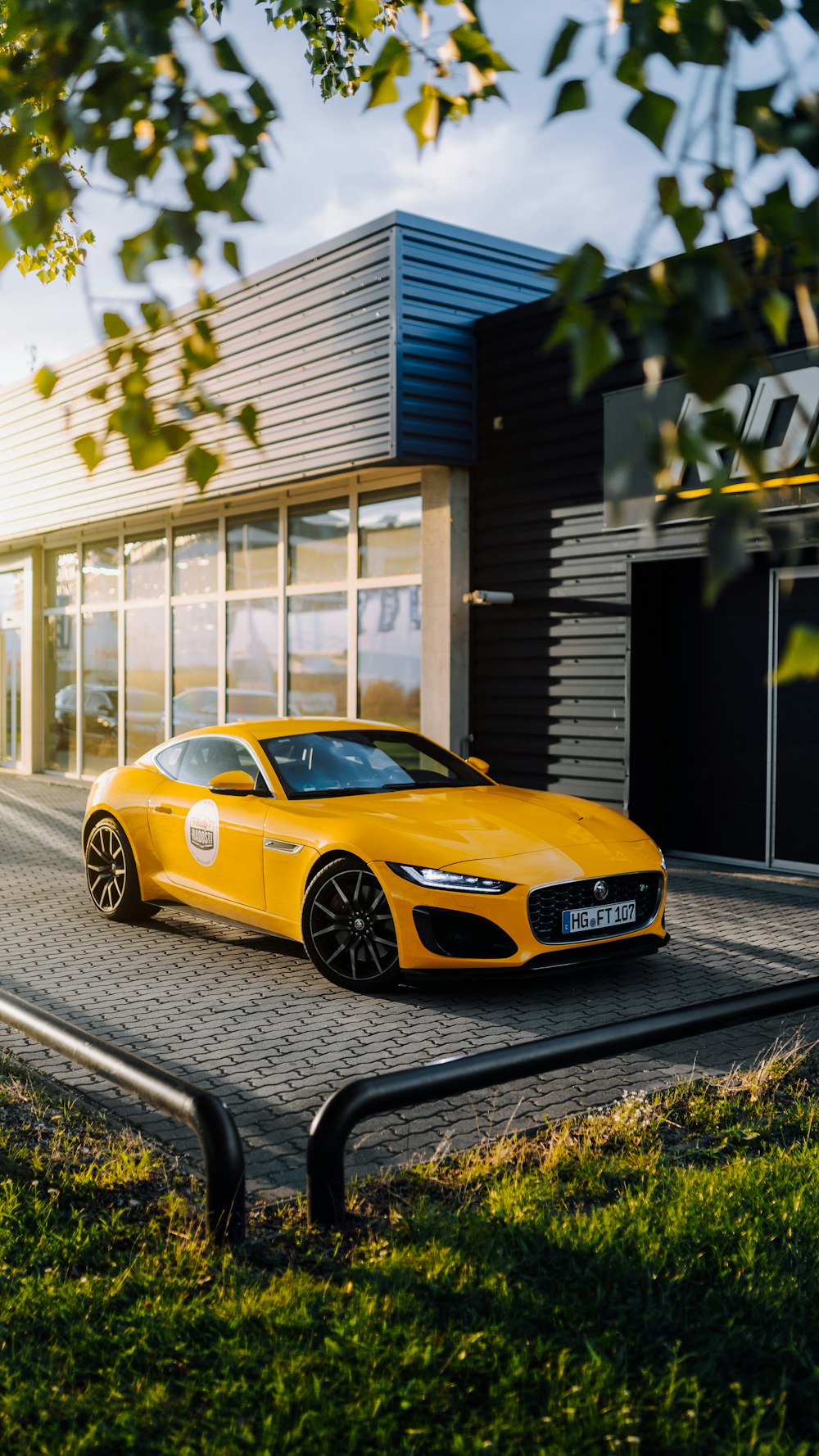 yellow porsche 911 parked in front of white and blue building