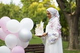 woman in white hijab holding bouquet of white flowers