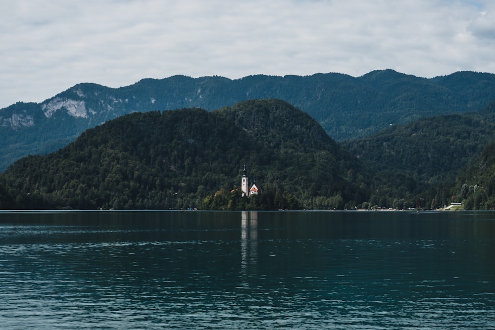 person standing on dock near mountain during daytime