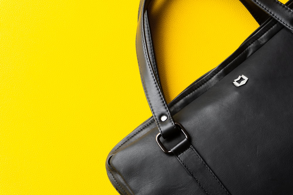 a black purse sitting on top of a yellow table