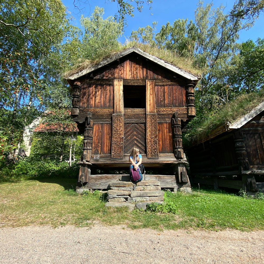 brown wooden house near green trees during daytime