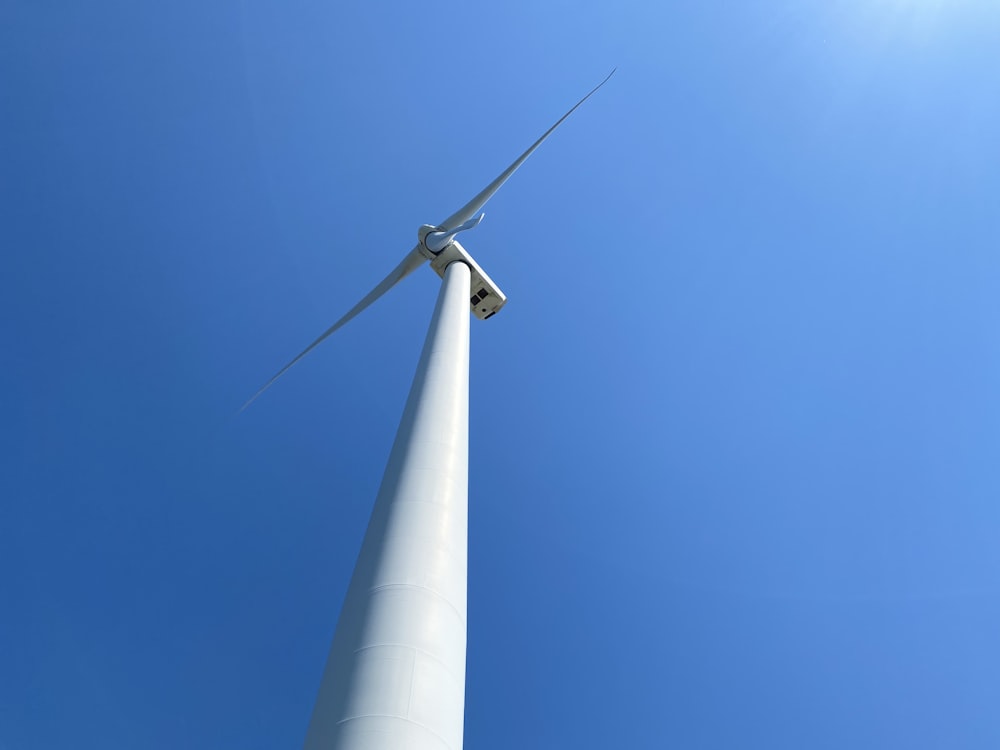 white wind turbine under blue sky during daytime