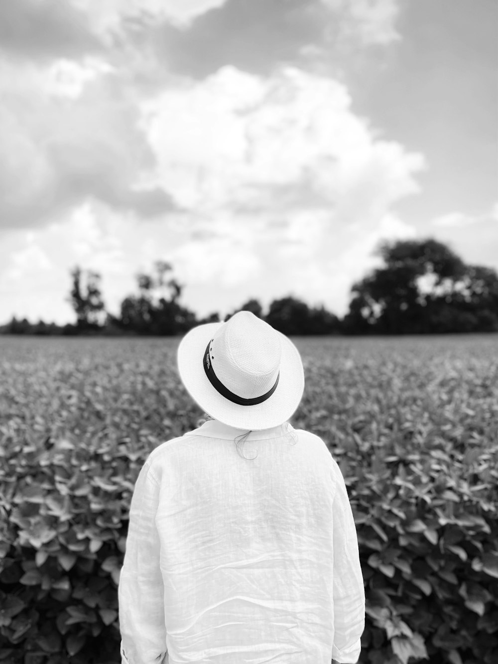 grayscale photo of woman in hat and long sleeve shirt