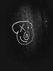 A bright sketch board with a hand drawing a smiley face.