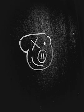 A bright sketch board with a hand drawing a smiley face.