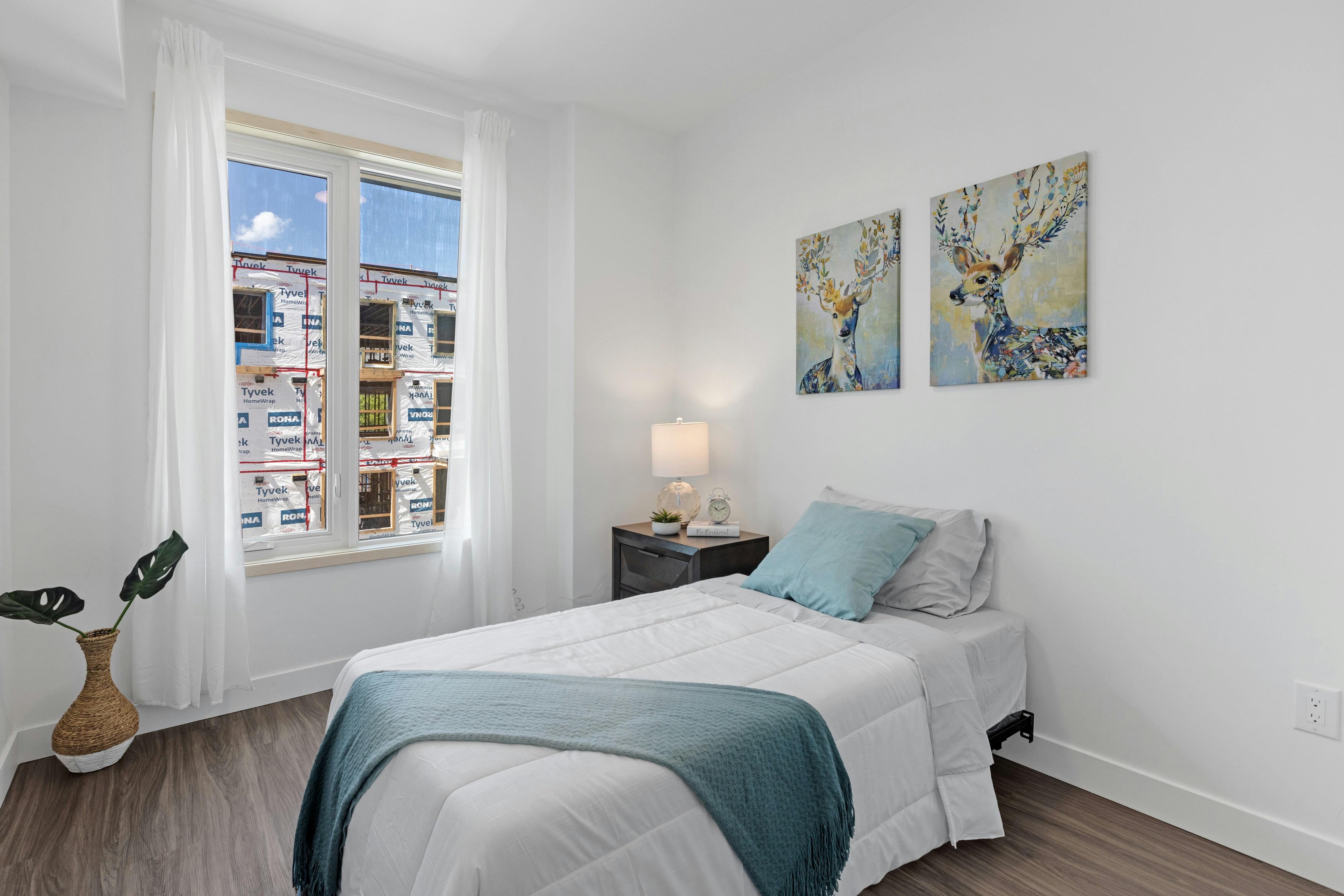 white bed linen near white wall