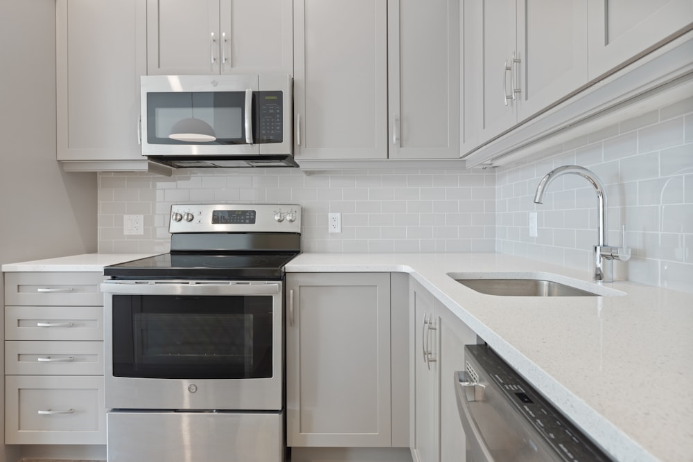 white microwave oven on white wooden kitchen cabinet