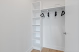 white wooden shelf with black and white shoes