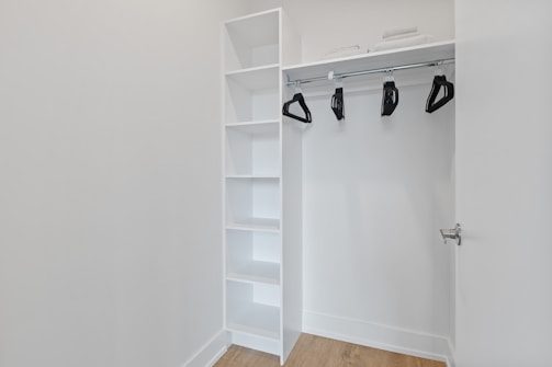 white wooden shelf with black and white shoes
