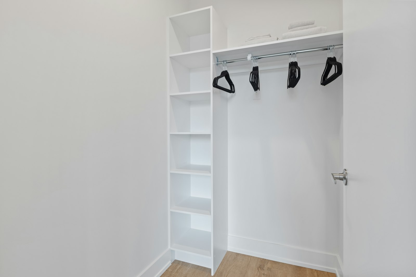 Black hangers waiting in an empty white closet