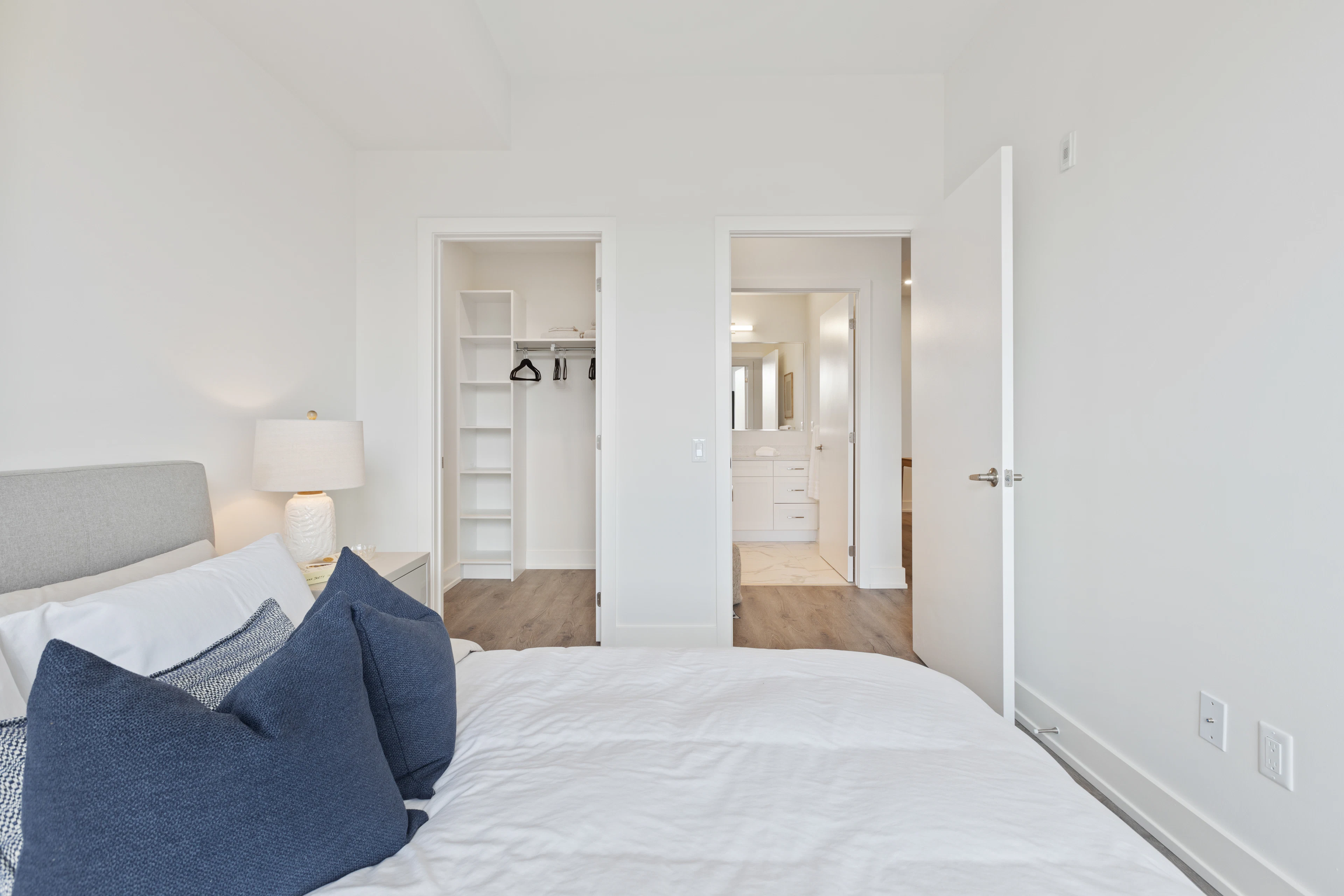 Bed with blue cushions by a doorway