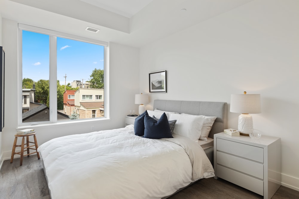 white bed linen with blue throw pillows