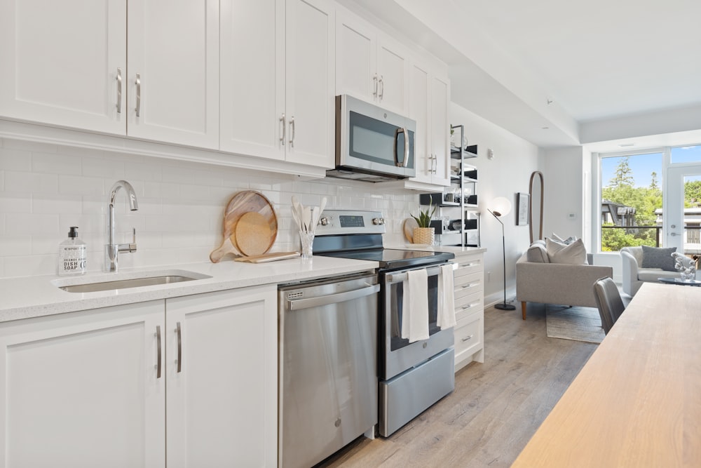 Horno microondas blanco en mueble de cocina de madera blanca