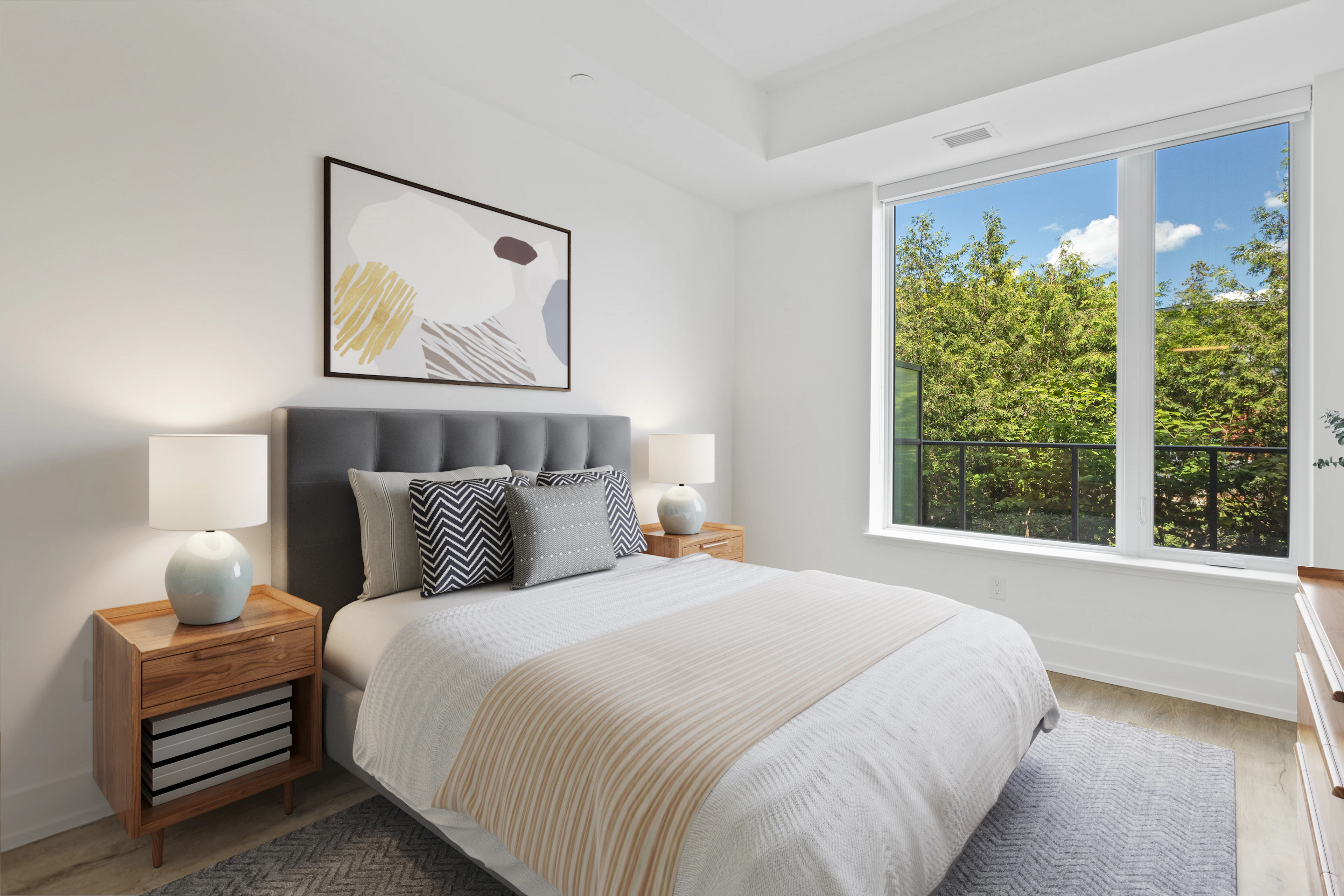 Bedroom with a grey headboard and a window