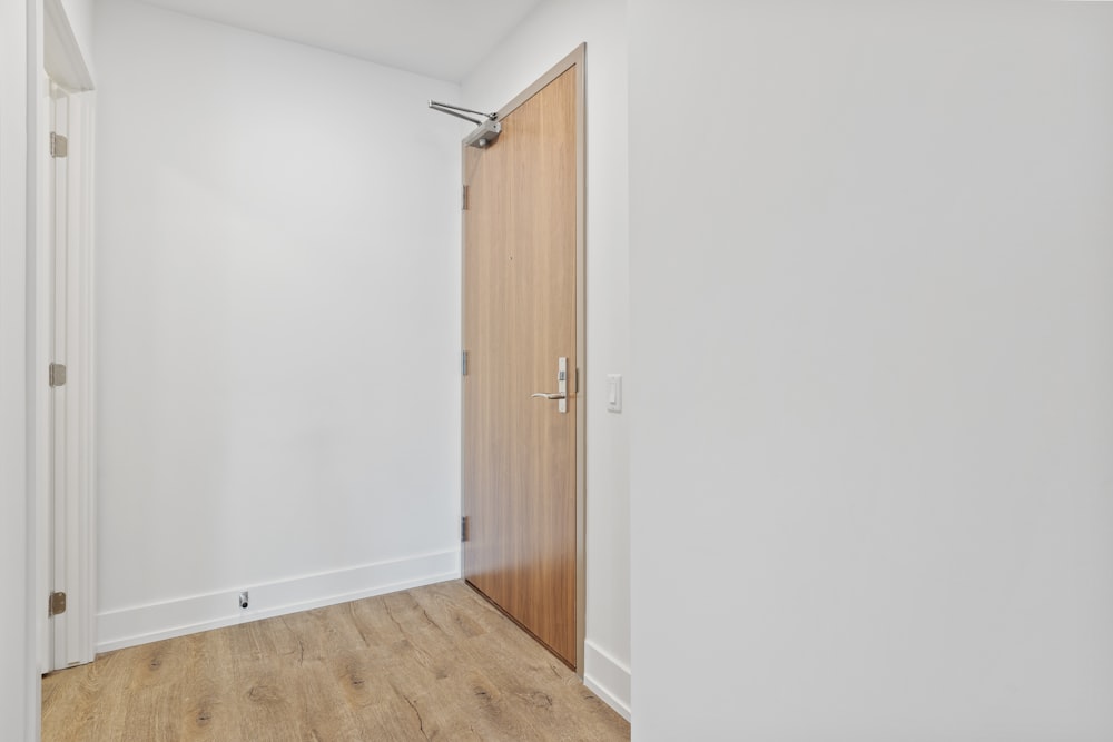 brown wooden door near white wall