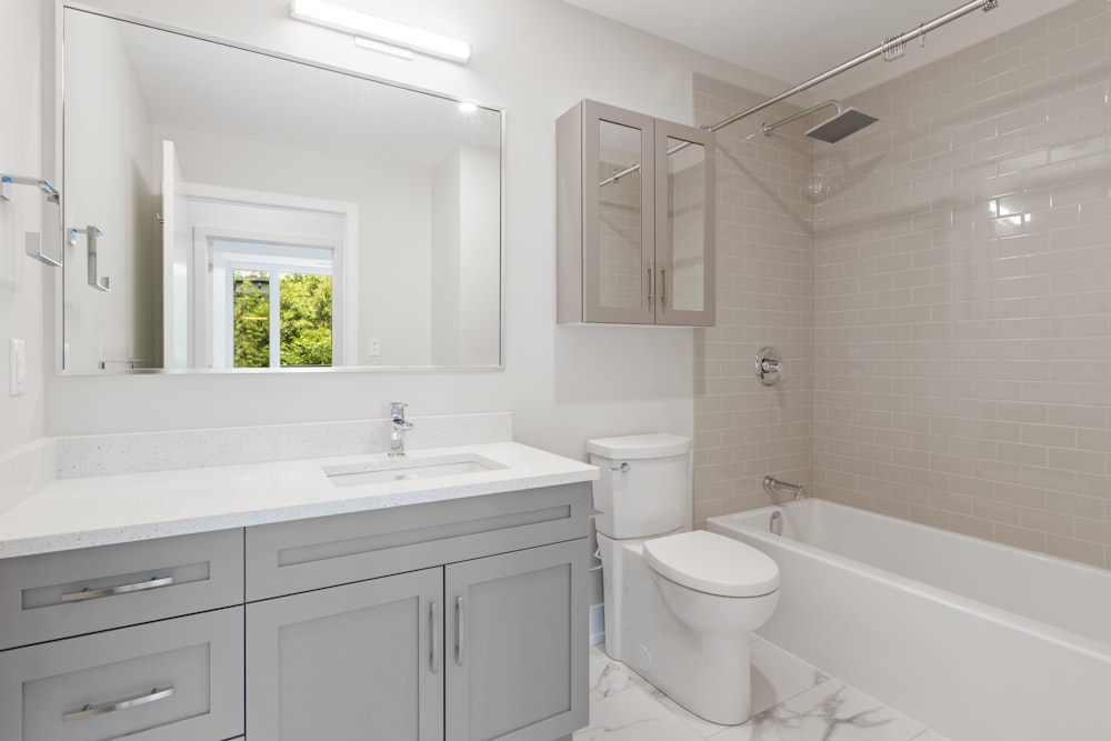 white ceramic toilet bowl near white ceramic sink