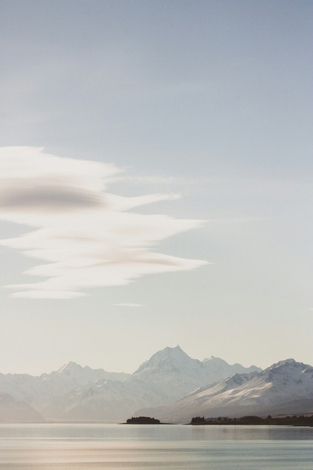 montagnes enneigées sous un ciel nuageux blanc pendant la journée