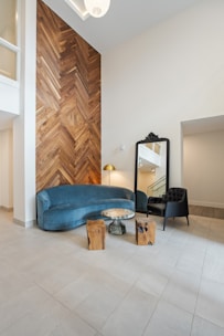blue cushion couch beside brown wooden door