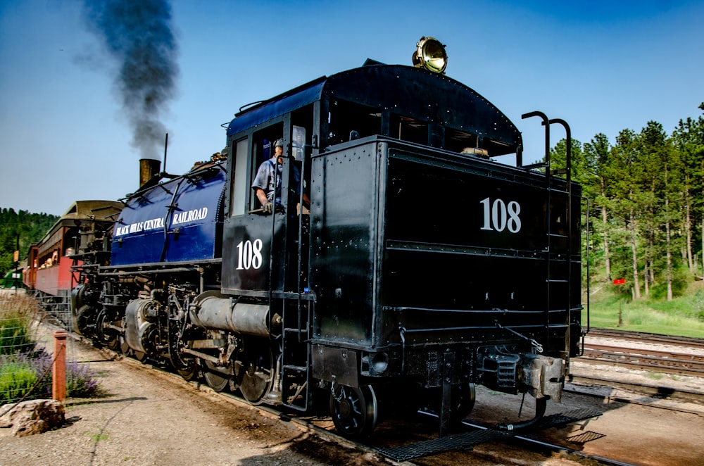 blue and black train on rail tracks during daytime