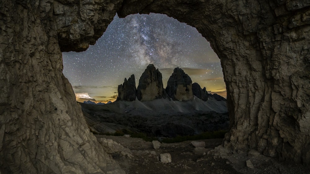 a view of the night sky through a cave