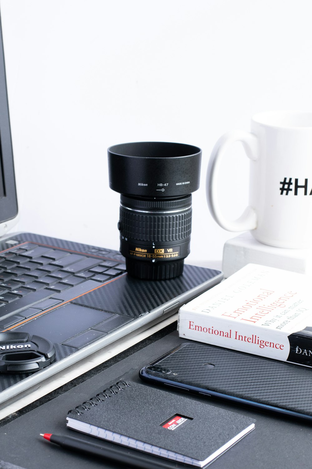 black and white ceramic mug beside black laptop computer