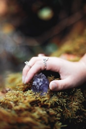 silver diamond ring on persons finger
