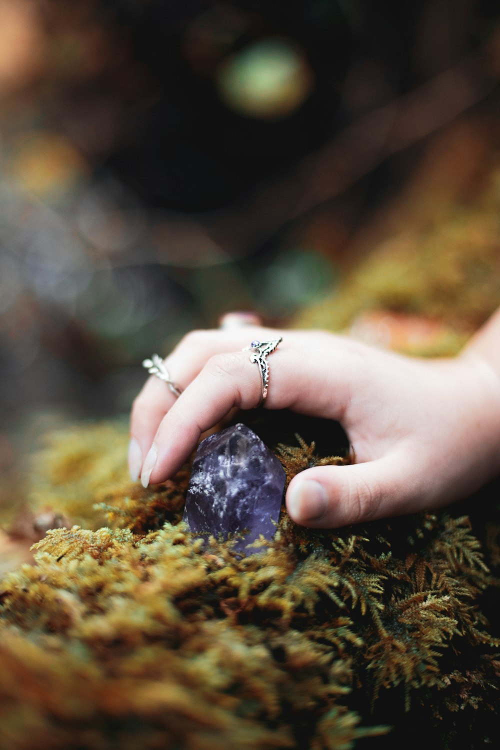 silver diamond ring on persons finger