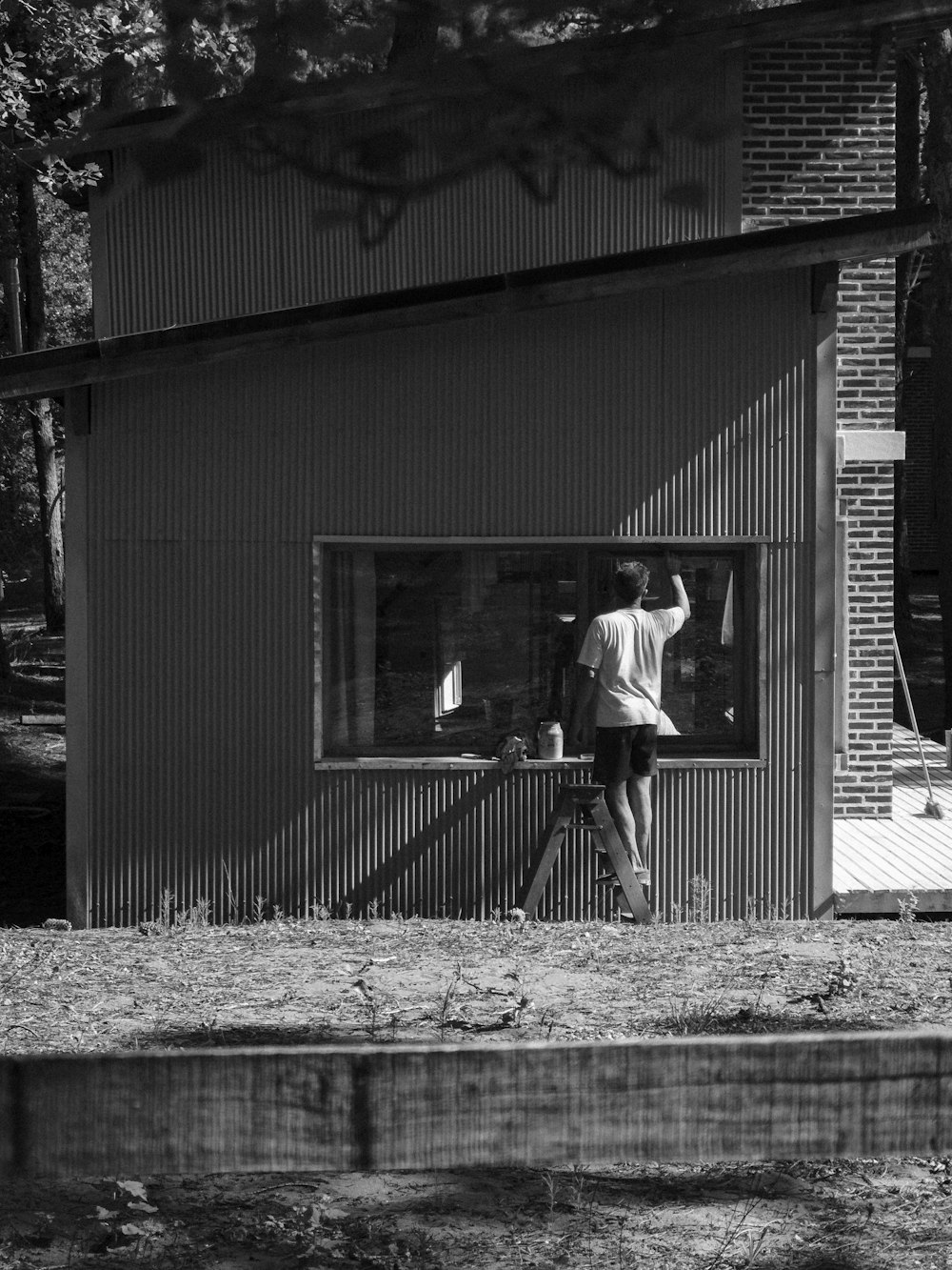 man in white shirt and black pants standing in front of garage door