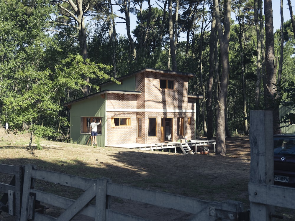 brown wooden house near green trees during daytime