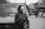 Image of a young woman checking her phone with a delivery truck in the background.