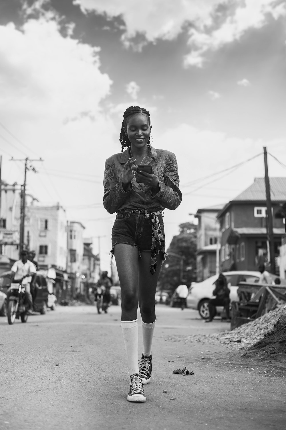 a black and white photo of a woman walking down a street