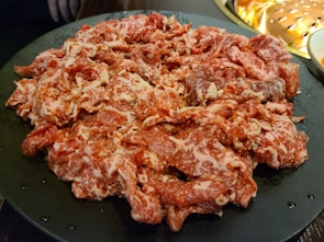 Close-up of marinated dana döner slices ready for cooking.