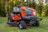 orange and black ride on lawn mower on green grass field during daytime
