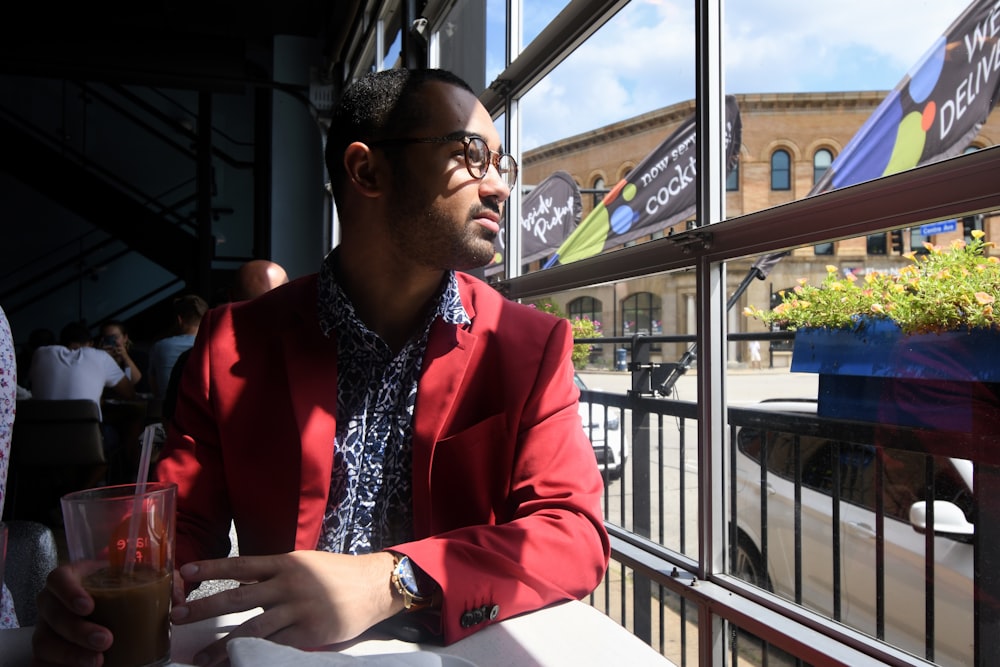 woman in red blazer sitting by the window