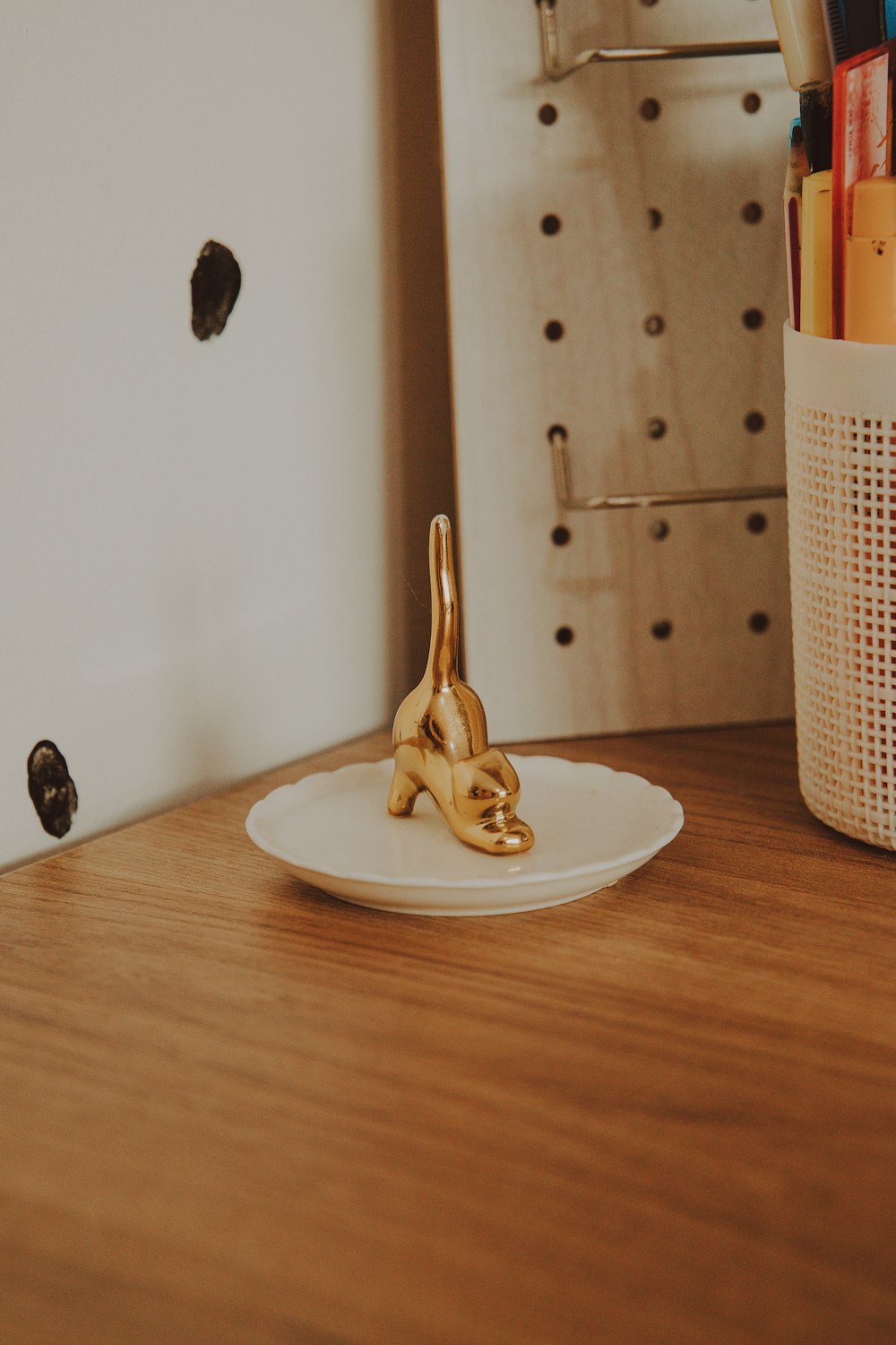 brown wooden figurine on white ceramic plate