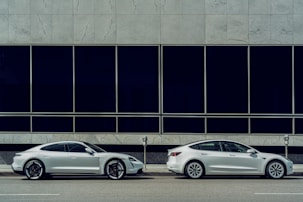 white sedan parked beside white and black building