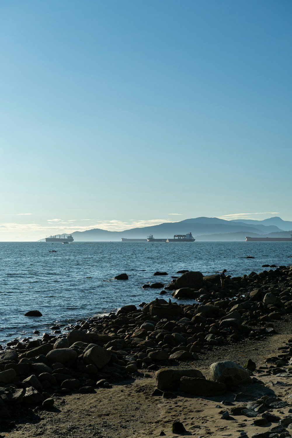 black rocks on sea shore during daytime