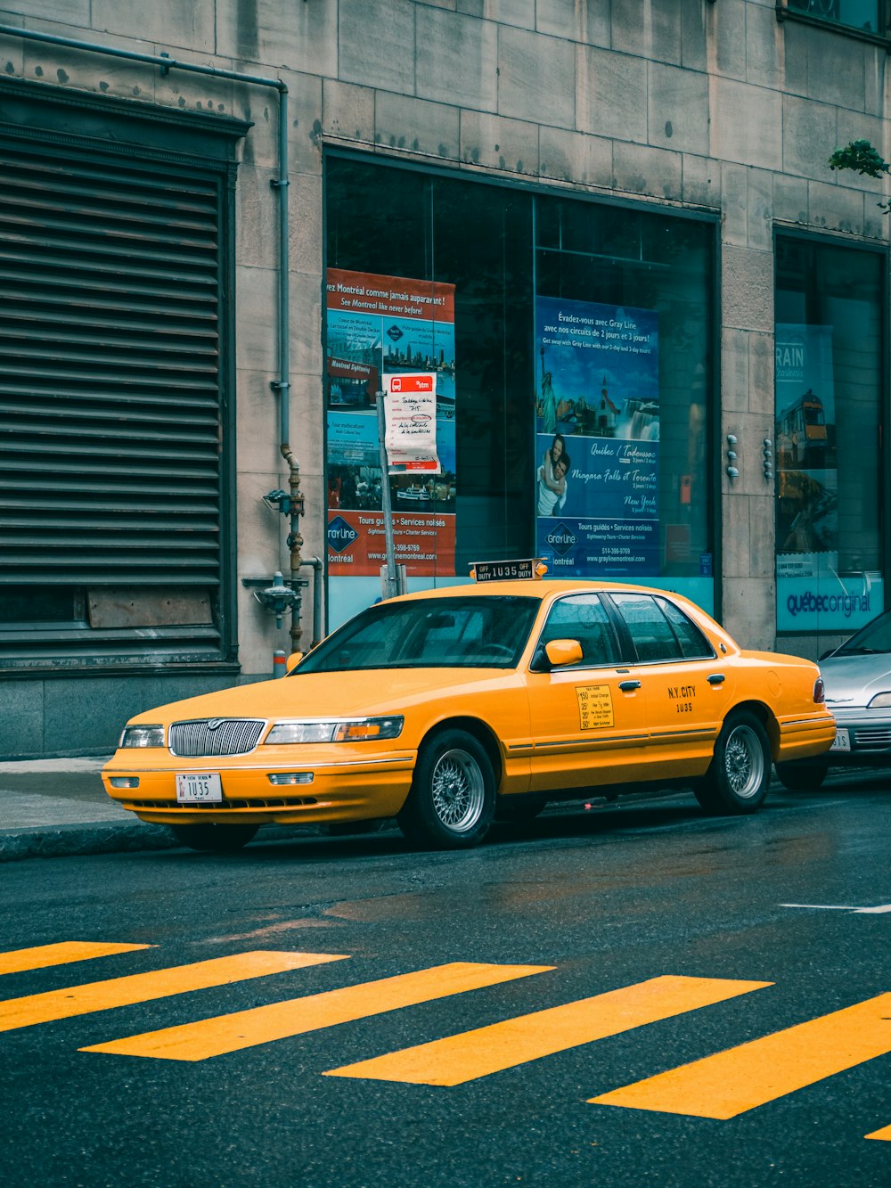 昼間の路上を走る黄色いタクシー