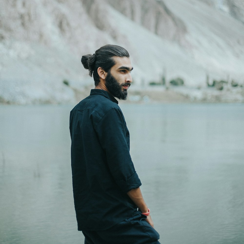 a man standing in front of a body of water